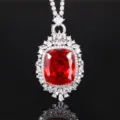 Primo piano di ciondolo in zircone rosso brillante con alone di pavé di zirconi bianchi. - Ciondolo Rosso Arancio Con Catena Versatile