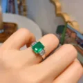 Dettagliato primo piano del bellissimo anello con gemma verde rettangolare indossato. - Taglia 6 / Verde smeraldo