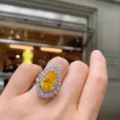 Primer plano detallado de un anillo de piedra amarilla en forma de pera usado en la mano. - Anillo Abierto de Strass Amarillo