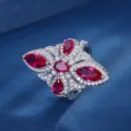 Primo piano dettagliato di un squisito anello in argento con pietre rosse e bianche. - Anello / Anello di Corindone Rosso