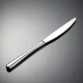 Detailed view of the 304 stainless steel dinner knife, featuring a smooth handle and polished finish. - Dinner Knife