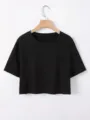Close-up detail van een eenvoudig zwart crop top met korte mouwen, zachte stof en ronde hals. - S / Zwart