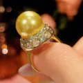 Primo piano di un lussuoso anello con perla dorata e incastonatura a pavé brillante. - Taglia 6 / Oro Perla Dorata