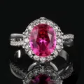 Primo piano dettagliato dell'elegante anello ovale con gemma rosa e contorno zirconi chic. - Taglia 6 / Corindone Rosso 3#