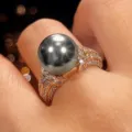 Primo piano di un anello vintage placcato in rame con perla scura e pietre lucide brillanti. - Taglia 6 / Grigio