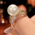 Primo piano dettagliato di un anello vintage placcato in rame con perla da 12mm e pietre lucenti. - Anello con Perla Bianca / Taglia 6