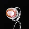 Primo piano dettagliato del lussuoso anello halo ovale in pietra preziosa color pesca con pavè. - Taglia US 5 / Anello Strass Taglio Ghiaccio Arancio-Rosa / Rosa Padparadscha