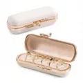 Portable mini capsule jewelry box with rose gold trim, open and closed view showing ring slots. - Off White