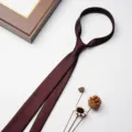 Dettaglio cravatta formale da uomo bordeaux tinta unita, tessuto liscio e taglio sartoriale. - Rosso Vino Scuro