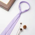 Dettaglio cravatta con zip viola, che mostra una consistenza liscia e un nodo pre-annodato - Viola Chiaro