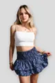 Vista dettagliata e curata dell'elegante crop top bianco e della minigonna blu. - Foglia Blu Scuro