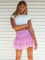 Dettaglio del top corto bianco estivo e della minigonna rosa con volant floreali. - Taglia S / Pantaloni e gonne / Rosa