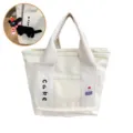 Canvas tote bag with cute embroidery and lunch bag design, durable and stylish for daily use. - Cake / With Black Doll Charm