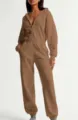Detail view of the brown hooded zip jumpsuit, showcasing the elastic waist and cozy fabric. - XS / Brown