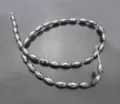 Faceted hematite magnetic bead detail, 6x12mm olive shape, smooth polished black surface. - Black Magnetic Bead