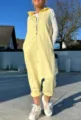 Detail shot of the sleeveless hooded yellow jumpsuit showcasing zipper and harlem style. - XS / Yellow