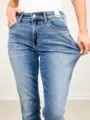 Nahaufnahme von blauen Damen Mid-Waist Stretch Jeans, die perfekte Gewebeelastizität zeigen. - XS / Mittelblau