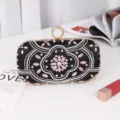 Black satin evening clutch bag with sparkling rhinestones, pearls, and elegant ring clasp design. - Black