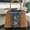 Detailed view of the woven rattan handbag with elegant embroidered floral panel and dual handles. - Trapezoidal Tote Basket / 26x18x16cm / Blue