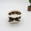 Detailed view of white woven storage basket with brown ribbon bow, perfect for desktop use. - Diameter 10 * 5 cm / Brown Monogram