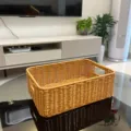 Detailed view of handwoven imitation rattan storage basket on glass table for home organization. - Rectangular Storage Basket / Small (33x23x11cm) / Natural Wood Color