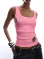 Pink ribbed knit tank top for women, featuring edgy metal eyelet and stud details, slim fit. - Pink