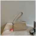 Detailopname van de beige lederen schoudertas, zachte textuur en strakke ritssluiting. - Met Hanger / Khaki
