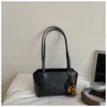 Detailaufnahme der schwarzen minimalistischen PU-Leder-Umhängetasche mit Holzperlenanhänger. - Mit Anhänger / Schwarz