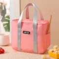Pink insulated lunch bag for women and students with sturdy handles and side pocket storage. - Pink