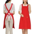 Red cotton polyester work apron with cross back straps and front pocket for kitchen cooking. - Polyester / Red