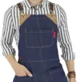 Durable denim work apron with cross-back straps, leather accents, and multi-pockets. - Blue