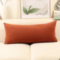 Vista detallada de cojin rectangular largo de chenilla marron anaranjado en sofa nordico estilo. - Caramelo