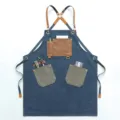 Vintage denim canvas work apron with leather straps and multiple tool pockets for barbers. - Blue