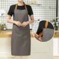 Grey canvas kitchen apron with adjustable brown straps and pocket, stylish workwear for cooking. - Waterproof Canvas Halterneck Contrast - Brown