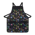 Détail du tablier de coiffure noir avec des motifs colorés d'outils de salon et poches zippées. - Motif de coiffeur multicolore sur fond noir