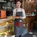 Tablier en denim de style coréen avec poches en cuir contrastées, idéal pour café et cuisine. - Style Tour de Cou Sangle en Denim / Gris