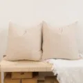 Skandinavischer Kord Kissenbezug Detailansicht mit zwei beige Kissen auf gewebter Bank. - 30*50cm (Kissenbezug) / Gebrochenes Weiß