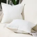 Close-up detailed shot of soft white corduroy striped pillow cover for modern sofa decor. - White