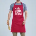 Detail view of a red cooking apron featuring a front pocket and white novelty print graphic. - Red QUEEN