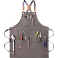Canvas work apron detail showing multi-pocket tool storage and durable hardware. - Black and Gray