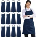 Dark blue polyester kitchen apron with front pockets and adjustable neck strap for cooking. - Polyester (Pack of 12) / Navy Blue