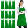 Pack of 12 green polyester aprons with pockets and adjustable neck straps for kitchen cooking. - Polyester (Pack of 12) / Green