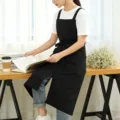 Black cotton linen apron with pockets, adjustable straps, ideal for kitchen, cafe, or floral work. - Black