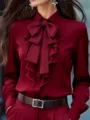 Elegante blusa burdeos de manga larga con cuello solapa, gran lazo y elegante botonadura de volantes. - Burdeos