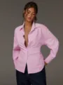 Vista dettagliata di una camicia da donna a righe rosa con collo a risvolto e maniche. - Taglia S / Rosa
