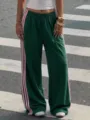 Detail shot of Y2K high-waist track pants with pink side stripes and comfortable drape. - Dark Green and Pink Stripes