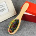 Wooden cushion hairbrush with colorful wavy bristles for daily hair care and massage. - Round Handle Rainbow