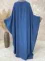 Detail view showcasing the flowy batwing sleeves and comfortable loose fit of the solid color maxi dress. - S / Dresses / Blue