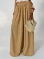 Detailed view of pleated wide-leg trousers, elastic high waist drape design in classic khaki. - Khaki
