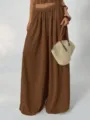 Detailed view of women's brown pleated high waist wide leg pants set with elegant drape and style. - Dark Brown